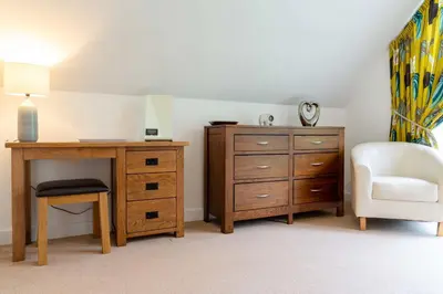 a bedroom with a desk and a chair and a dresser at Trewhiddle Retreat V21 by Together Travel - Luxury 3-Bedroom Villa in St Austell