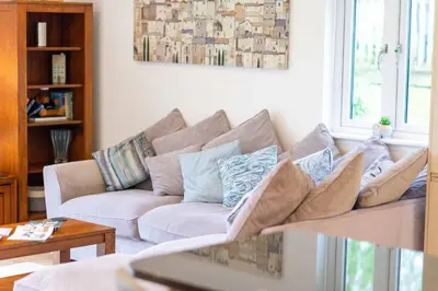 a living room with a couch with pillows on it at Trewhiddle Retreat V21 by Together Travel - Luxury 3-Bedroom Villa in St Austell