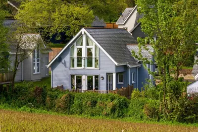 a blue house with a gray roof at Trewhiddle Retreat V21 by Together Travel - Luxury 3-Bedroom Villa in St Austell