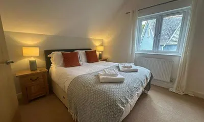 a bedroom with a bed with two towels on it at Trewhiddle Retreat V18 by Together Travel - Luxury 4-Bedroom Villa in St Austell