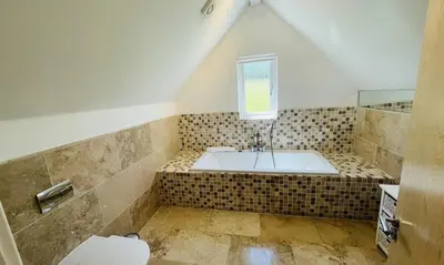 a bathroom with a tub and a toilet and a window at Trewhiddle Retreat V18 by Together Travel - Luxury 4-Bedroom Villa in St Austell
