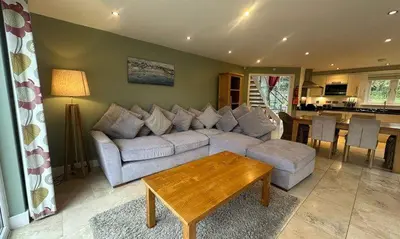 a living room with a couch and a table at Trewhiddle Retreat V18 by Together Travel - Luxury 4-Bedroom Villa in St Austell