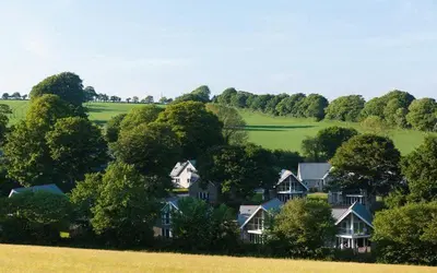a group of houses in a field with trees at Trewhiddle Retreat V20 by Together Travel - Luxury 3-Bedroom Villa in St Austell