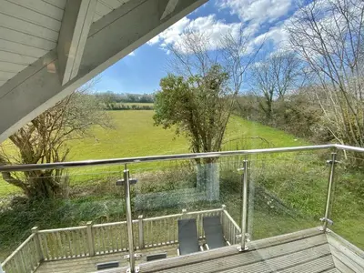 a balcony with a view of a field at Trewhiddle Retreat V17 by Together Travel - Luxury 4-Bedroom Villa in St Austell
