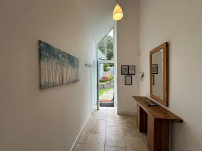 a hallway with a table and a mirror on a wall at Trewhiddle Retreat V17 by Together Travel - Luxury 4-Bedroom Villa in St Austell