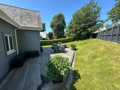 a backyard with a deck with a table and chairs at Trewhiddle Retreat V14 by Together Travel - Luxury 4-Bedroom Villa in St Austell