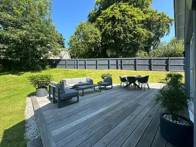 a wooden deck with chairs and a couch and a table at Trewhiddle Retreat V14 by Together Travel - Luxury 4-Bedroom Villa in St Austell