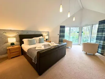 a bedroom with a large bed in a room at Trewhiddle Retreat V16 by Together Travel - Luxury 4-Bedroom Villa in St Austell