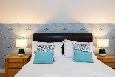 a bedroom with a white bed with two lamps at Trewhiddle Retreat V16 by Together Travel - Luxury 4-Bedroom Villa in St Austell