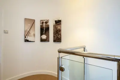 three pictures hanging on a wall next to a staircase at Trewhiddle Retreat V16 by Together Travel - Luxury 4-Bedroom Villa in St Austell