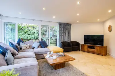 a living room with a couch and a television at Trewhiddle Retreat V16 by Together Travel - Luxury 4-Bedroom Villa in St Austell