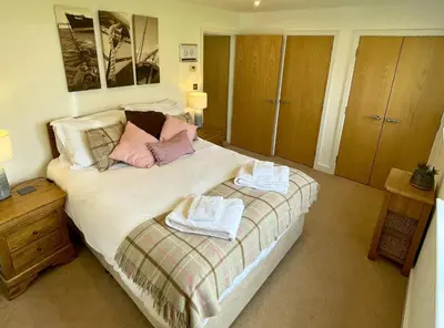 a bedroom with a bed with towels on it at Trewhiddle Retreat V12 by Together Travel - Luxury 4-Bedroom Villa in St Austell