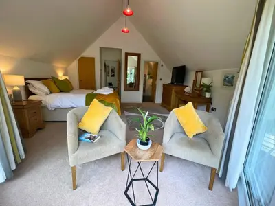 a living room with two chairs and a bed at Trewhiddle Retreat V12 by Together Travel - Luxury 4-Bedroom Villa in St Austell