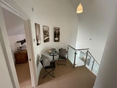 a staircase with a table and chairs in a room at Trewhiddle Retreat V12 by Together Travel - Luxury 4-Bedroom Villa in St Austell