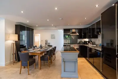 a kitchen and dining room with a table and chairs at Trewhiddle Retreat V11 by Together Travel - Luxury 4-Bedroom Villa in St Austell