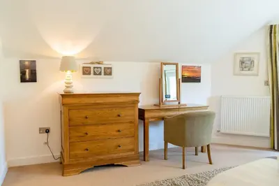 a bedroom with a dresser and a mirror and a desk at Trewhiddle Retreat V11 by Together Travel - Luxury 4-Bedroom Villa in St Austell