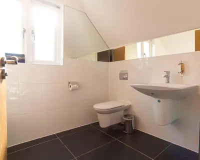 a white bathroom with a sink and a toilet at Trewhiddle Retreat V11 by Together Travel - Luxury 4-Bedroom Villa in St Austell