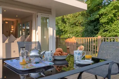 a table with a tea kettle and a bowl of food at Trewhiddle Retreat V11 by Together Travel - Luxury 4-Bedroom Villa in St Austell