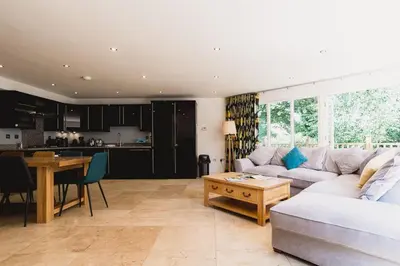 a living room with a couch and a table at Trewhiddle Retreat V10 by Together Travel - Luxury 4-Bedroom Villa in St Austell
