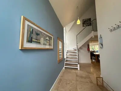 a staircase in a house with a picture on the wall at Trewhiddle Retreat V10 by Together Travel - Luxury 4-Bedroom Villa in St Austell