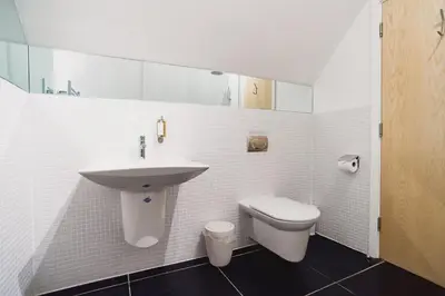 a white bathroom with a sink and a toilet at Trewhiddle Retreat V10 by Together Travel - Luxury 4-Bedroom Villa in St Austell