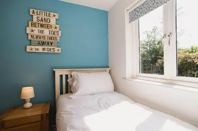 a small bedroom with a bed and a window at Trewhiddle Retreat V10 by Together Travel - Luxury 4-Bedroom Villa in St Austell