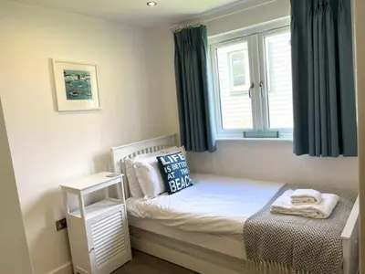 a small bedroom with a bed and a window at Trewhiddle Retreat V19 by Together Travel - Luxury 4-Bedroom Villa in St Austell