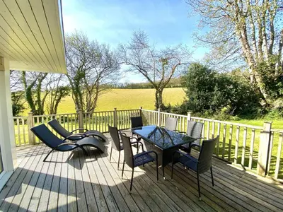 a patio with a table and chairs on a deck at Trewhiddle Retreat V19 by Together Travel - Luxury 4-Bedroom Villa in St Austell