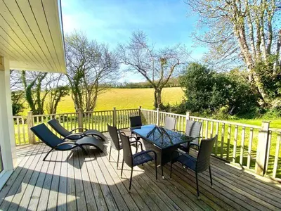 a patio with a table and chairs on a deck at Trewhiddle Retreat V19 by Together Travel - Luxury 4-Bedroom Villa in St Austell