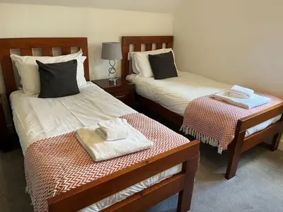 two beds in a room with towels on them at Trewhiddle Retreat V19 by Together Travel - Luxury 4-Bedroom Villa in St Austell