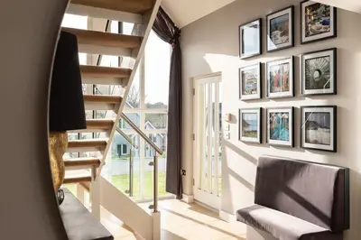 a living room with a staircase and a stair case at Trewhiddle Retreat V5 by Together Travel - Luxury 4-Bedroom Villa in St Austell