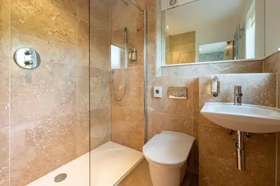 a bathroom with a shower and a toilet and a sink at Trewhiddle Retreat V5 by Together Travel - Luxury 4-Bedroom Villa in St Austell