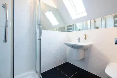 a white bathroom with a sink and a shower at Trewhiddle Retreat V5 by Together Travel - Luxury 4-Bedroom Villa in St Austell