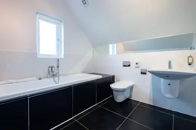 a white bathroom with a sink and a toilet at Trewhiddle Retreat V5 by Together Travel - Luxury 4-Bedroom Villa in St Austell