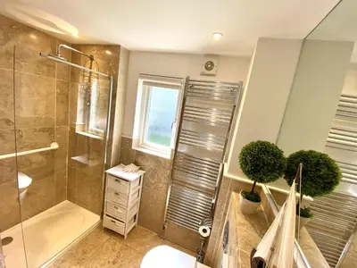 a bathroom with a shower and a toilet and a window at Trewhiddle Retreat V30 by Together Travel - Luxury 4-Bedroom Villa in St Austell