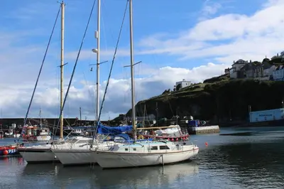 three sailboats are docked in the water in a harbor at Trewhiddle Retreat V30 by Together Travel - Luxury 4-Bedroom Villa in St Austell