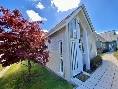 a white house with a door and a tree at Trewhiddle Retreat V30 by Together Travel - Luxury 4-Bedroom Villa in St Austell
