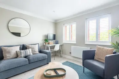 a living room with a couch and a chair and a mirror at Hideaway - Exclusive marina development, town centre, with parking in Falmouth