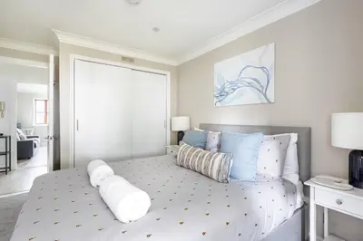 a bedroom with a large bed with blue and white pillows at Hideaway - Exclusive marina development, town centre, with parking in Falmouth