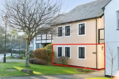 a house with a red stripe on the side of it at Hideaway - Exclusive marina development, town centre, with parking in Falmouth