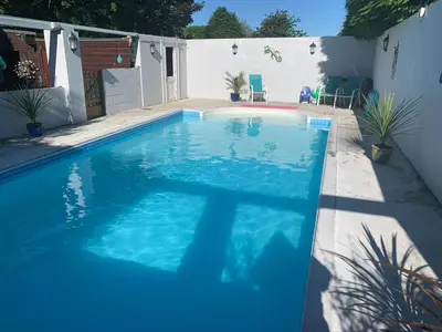 a swimming pool with blue water in a backyard at Silverspring Glamping The Shepherds Hut in Constantine