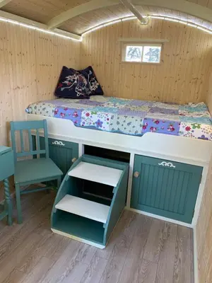 a bedroom with a bed and a bunk bed with a drawer at Silverspring Glamping The Shepherds Hut in Constantine