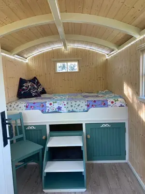 a bed and a chair in a small room at Silverspring Glamping The Shepherds Hut in Constantine