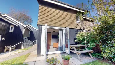 a house with a door open and a picnic table at 19 Strawberry Hill, Tolroy Manor in Hayle