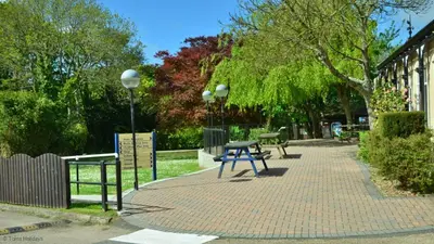 a picnic table on a brick sidewalk next to a building at 19 Strawberry Hill, Tolroy Manor in Hayle
