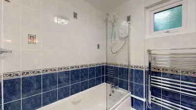 a bathroom with a shower and a bath tub at 24 Strawberry Hill, Tolroy Manor in Hayle