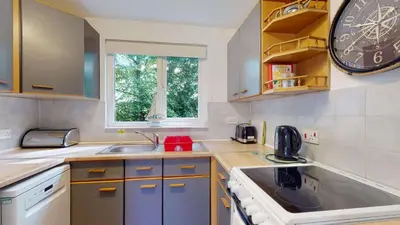a kitchen with a sink and a clock on the wall at 24 Strawberry Hill, Tolroy Manor in Hayle