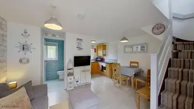 a living room with a kitchen and a dining room at 36 Strawberry Hill, Tolroy Manor in Hayle