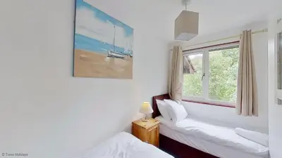 a room with two beds and a window at 36 Strawberry Hill, Tolroy Manor in Hayle