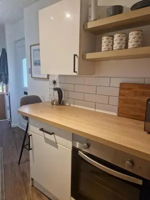 a kitchen with a wooden counter top and shelves at Cosy Self Contained Annexe in Bodmin